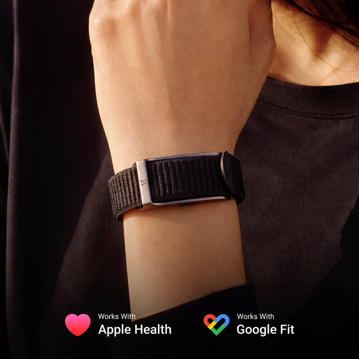 A woman wearing the HLTH Band on her wrist, with badges reading Works With Apple Health and Works With Google Fit